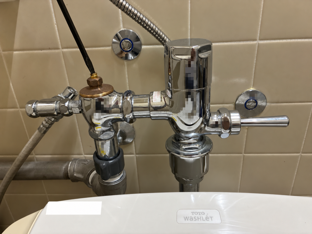 マイナスドライバーでトイレの止水栓を操作している様子