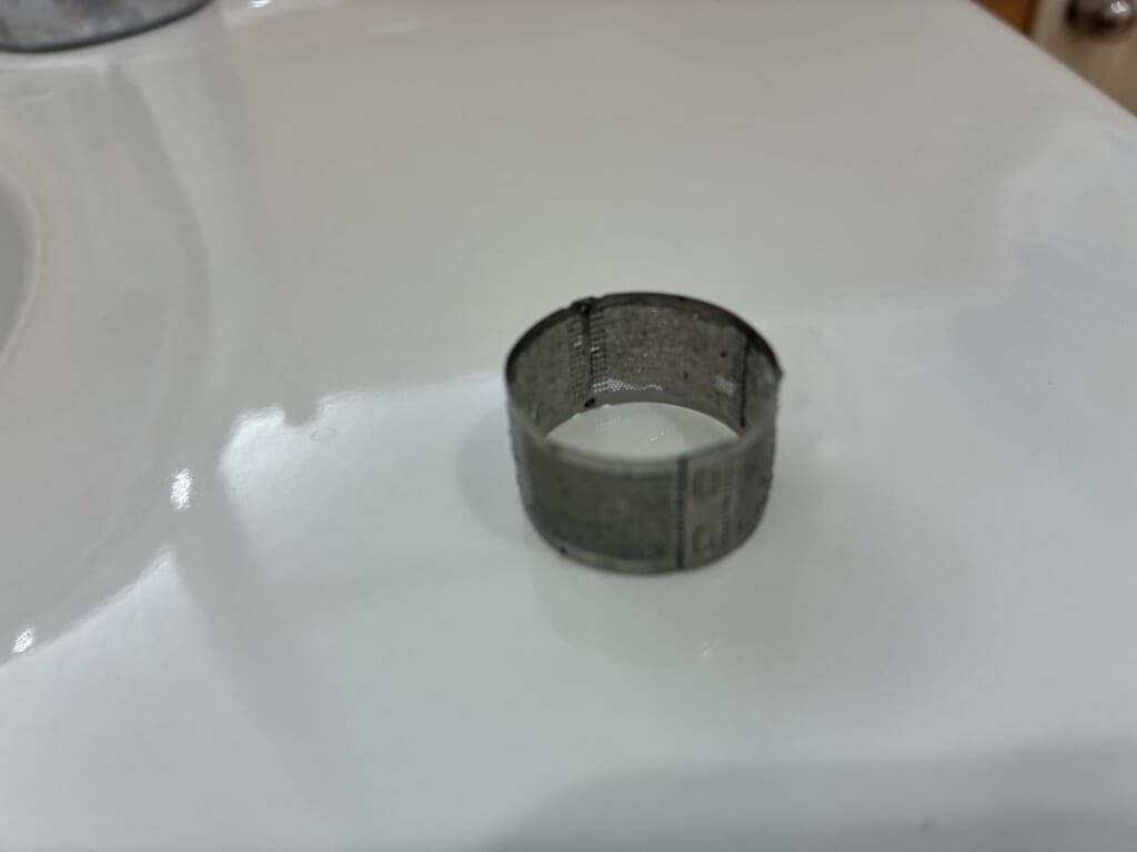 混合水栓から取り外した、網に付着物が見られるストレーナー