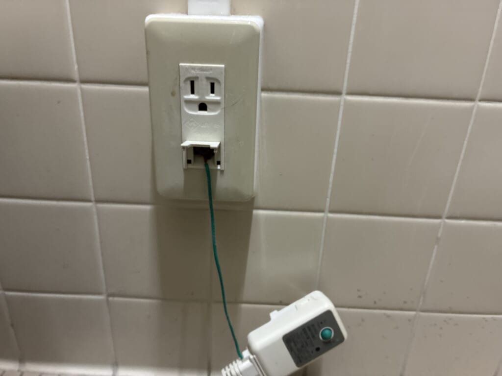 コンセントから抜いたウォシュレットの電源プラグと接続中のアース線